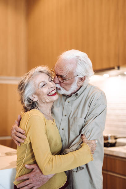 istock senior couple kissing on the kitchen 1021608154