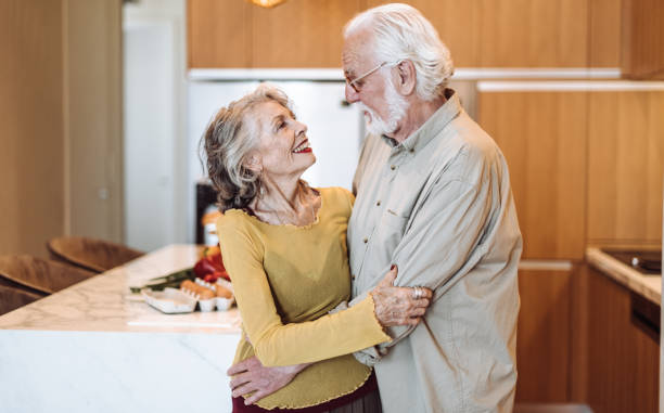 istock senior couple kissing on the kitchen 1021608178