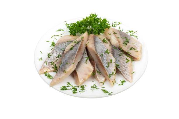 istock Herring fillets sliced with herbs on a plate isolated on white background 1021612214