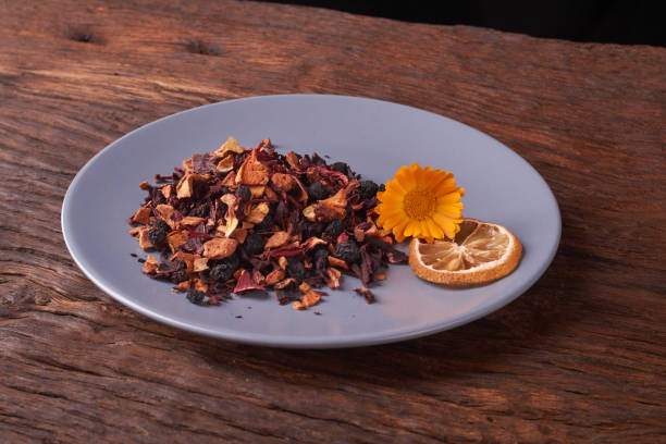 istock Black dry fruit tea leaves in blue plate on wooden table. Selective focus 1021616656