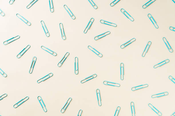 Bblue paper clips on yellow background. Back to school colorful flat lay
