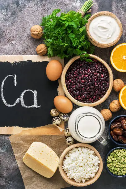 Photo of Food with calcium on a rustic background. Dairy products, legumes, nuts, greens, eggs. Top view. Flat lay.