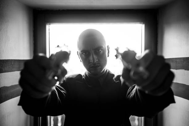Hooded man with a gun in the dark