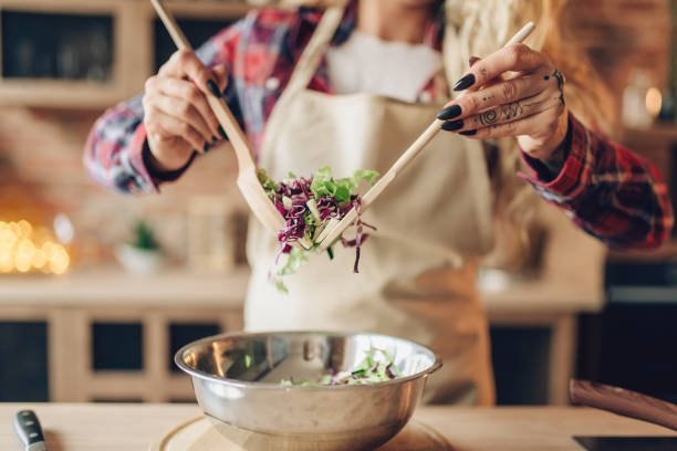 istock Female cook in apron prepares fresh salad 1021671648