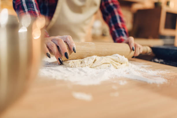 istock Housewife rolls out the dough with a rolling pin 1021674762