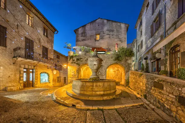 Famous fountain (La Grande Fontaine de 1850) at dusk in Saint Paul de Vence, Alpes-Maritimes, France