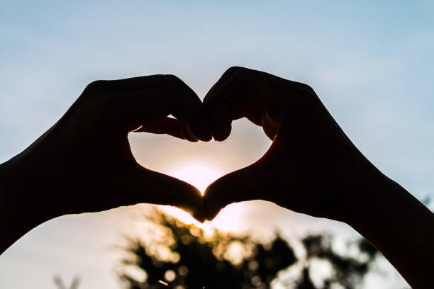 istock love shape hand silhouette at sunset 1021684520