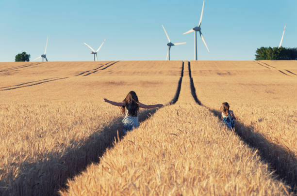 mädchen laufen der weg zur windenergie - fuel and power generation power wind power supply stock-fotos und bilder