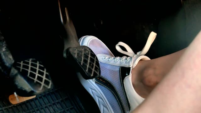 Girl on white snickers shoes pressing car pedals 4k