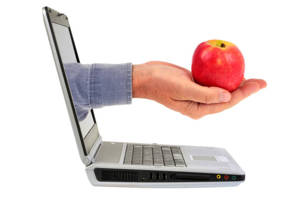 istock Holding an apple out of the computer 1021702496