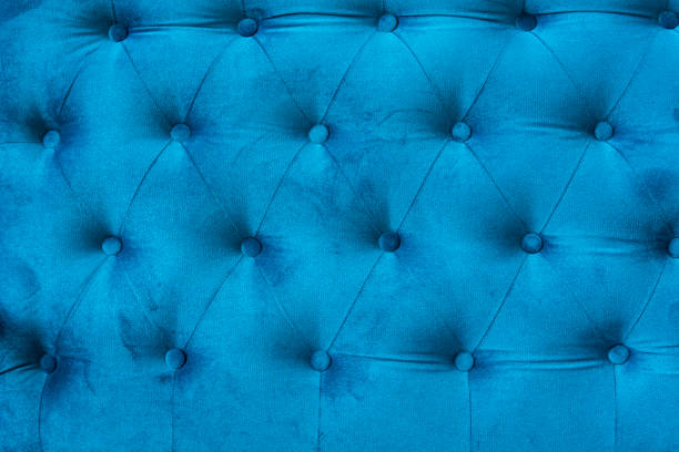istock Velour surface of sofa close-up. Coach-type velours screed tightened with buttons. Blue chesterfield style quilted upholstery backdrop close up. 1021706976
