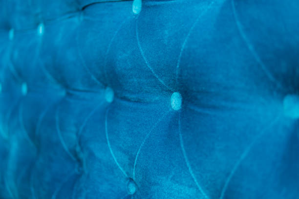 istock Velour surface of sofa close-up. Coach-type velours screed tightened with buttons. Blue chesterfield style quilted upholstery backdrop close up. 1021706986