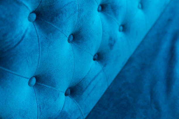 istock Velour surface of sofa close-up. Coach-type velours screed tightened with buttons. Blue chesterfield style quilted upholstery backdrop close up. 1021707050