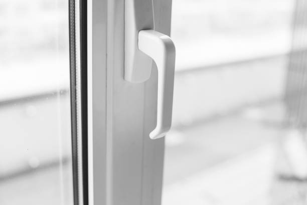 Close-up on a white handle of the pvc window. stock photo