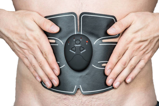 Male athlete wearing a electric ab muscle stimulator doing abs exercise stock photo