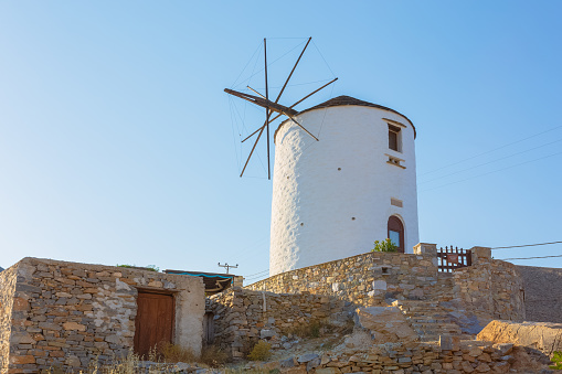 SYROS, JUNE 2017: Traditional windmill on top of San Georgio hill in Ano Syros, Cyclades, Greece.  There are various traditional windmills scattered in the countryside, some still in use by the locals.