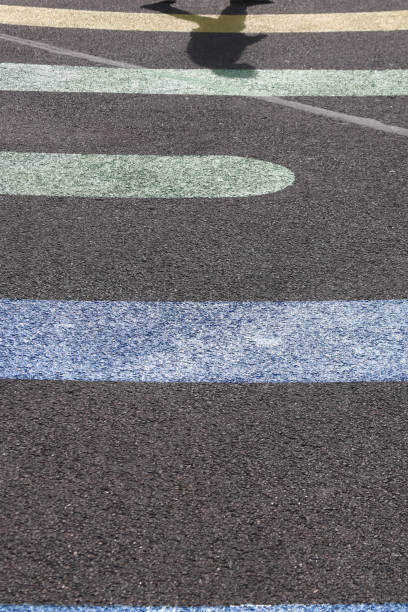 istock Walking man shadow on colored line shapes on asphalt surface texture. 1021728572