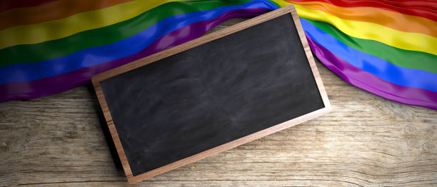 istock Rainbow flag placed on wooden background. Blackboard in frame with copyspace. 3d illustration 1021733696