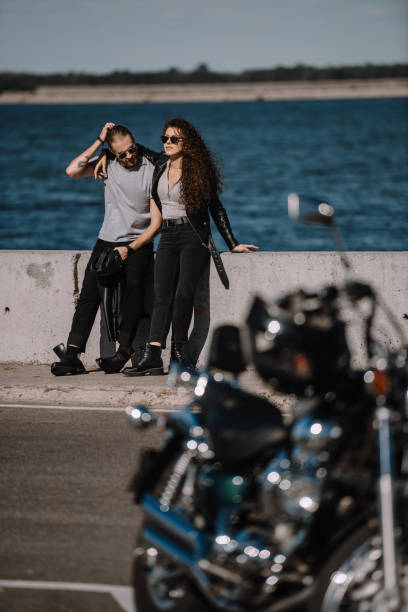 istock selective focus of young couple with motorcycle on foreground 1021733742
