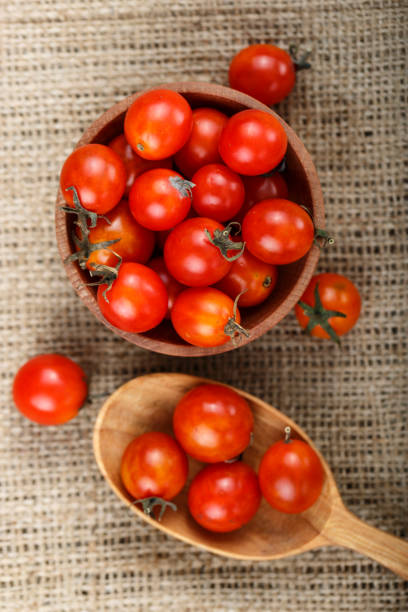 istock cherry tomatoes on sacking, next to the plate lies a wooden spoon. 1021734772