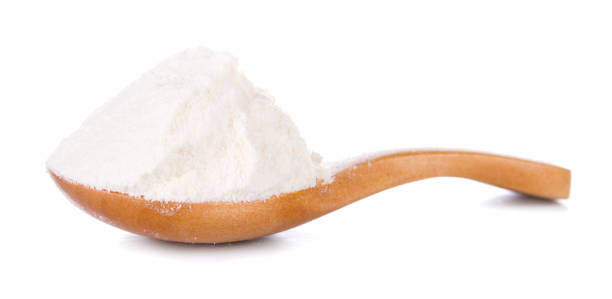 istock Wheat flour in wooden spoon isolated on white background 1021736240