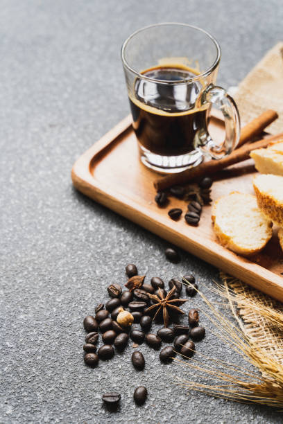 istock A coffee, bread, wood plate and book setting on black background 1021736264