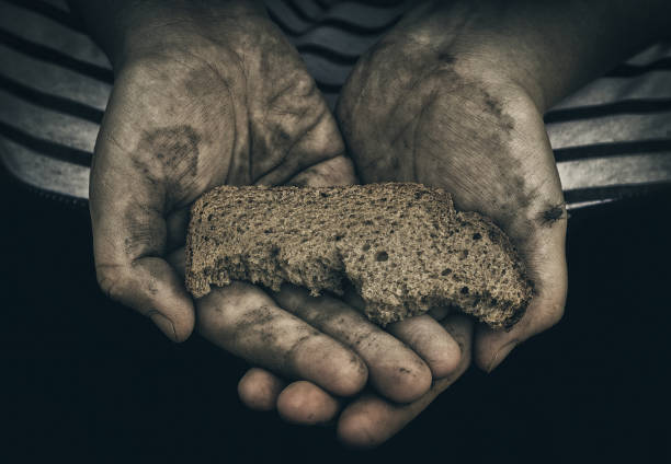 Dirty hands of homeless poor man with piece of bread. The concept of poverty and social inequality. Unemployment and hunger. Consequence of war. The lack of food. Economic crisis. Social inequality. Third world war. Panhandler. Almsman. Shortage of food. beg alms stock pictures, royalty-free photos & images