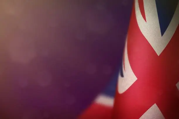Photo of United Kingdom (UK) flag for honour of veterans day or memorial day. Glory to the United Kingdom (UK) heroes of war concept on purple dark velvet background.