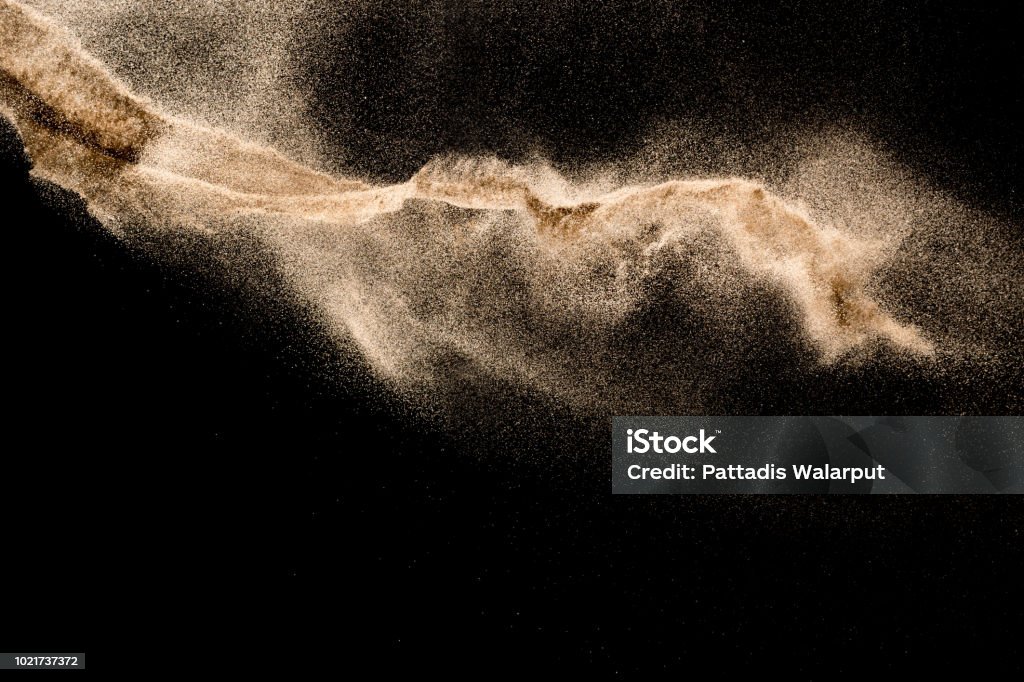 Golden sand explosion isolated on black background. Abstract sand cloud. Sand Stock Photo