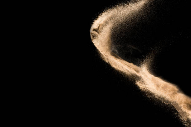 istock Golden sand explosion isolated on black background. Abstract sand cloud. 1021737476