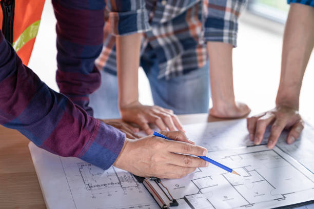 istock woman civil architect engineer discussion of building with building plan,engineering and architecture concept.Blue print is fake only for stock photo. 1021749786
