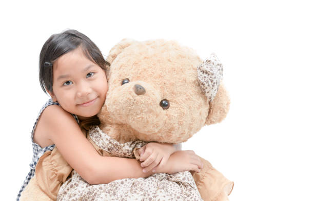istock Cute girl hugging big teddy bear isolated 1021755080