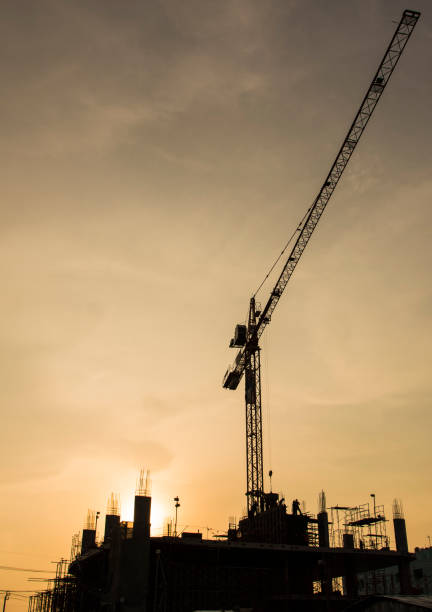 istock Silhouette construction site on sunset in evening time.Engineer and worker on building site. 1021755360