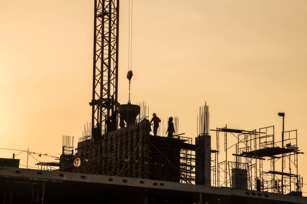 istock Silhouette construction site on sunset in evening time.Engineer and worker on building site. 1021755388