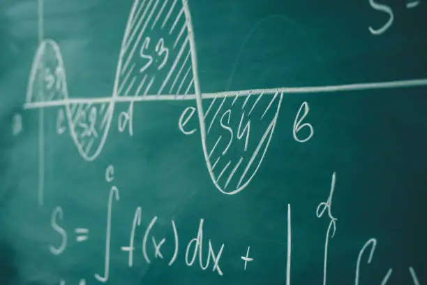 Photo of Mathematics function integra graph formulas on the chalkboard.