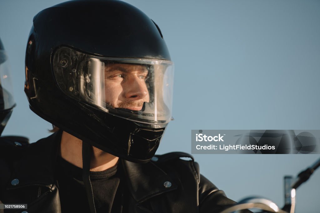 Retrato de hombre en motocicleta casco mirando lejos - Foto de stock de Motocicleta libre de derechos