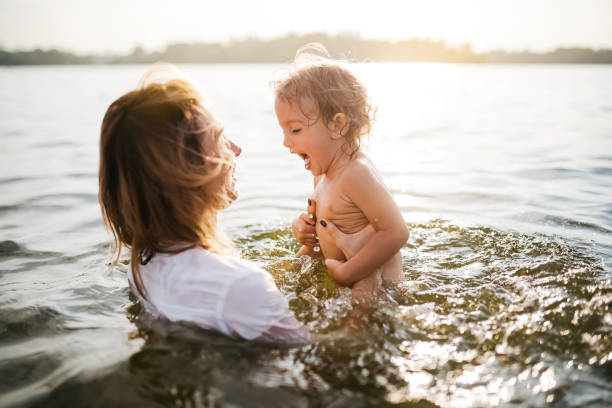 istock happy mother holding screaming daughter in river 1021782718