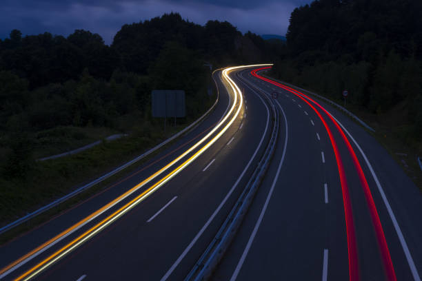 istock Car lights on a mountain road at dusk 1021790900