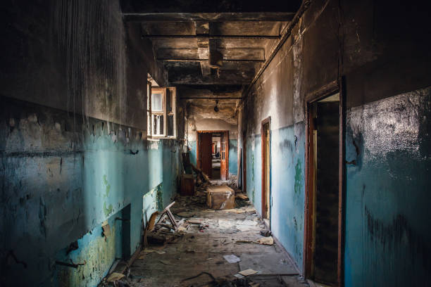 istock Dirty empty dark corridor in burned abandoned building after fire, broken doors, garbage, perspective 1021794316