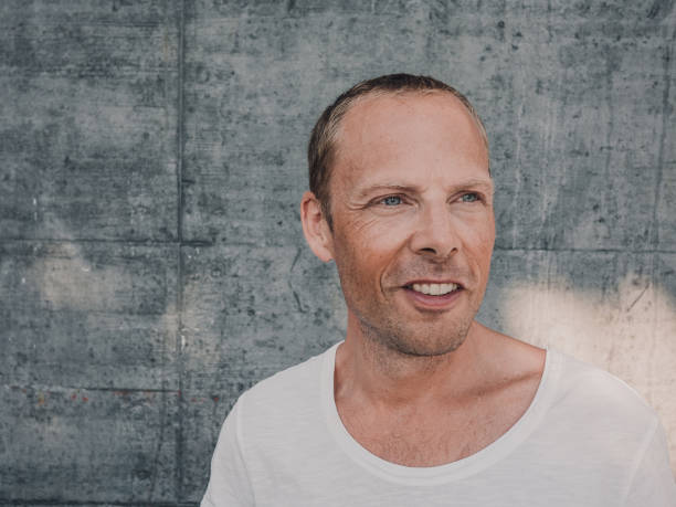 istock Casual real man with concrete background in city 1021794676