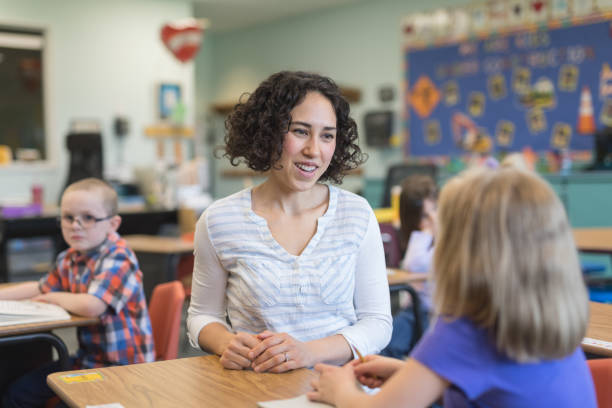 istock A first grade teacher talking with one of her students in the classroom 1021799486