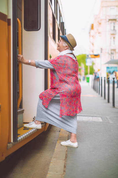 istock Senior woman is getting on the tram 1021808722