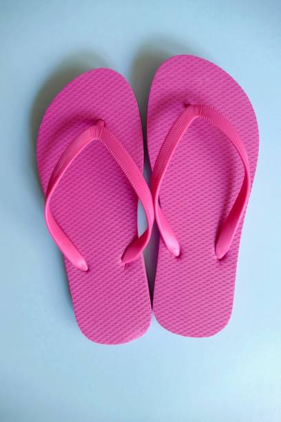 istock Pink flip flops on blue background 1021811950