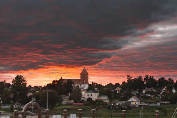 Photo of Mir, Belarus. Landscape Of Village Houses And Saint Nicolas Roman Catholic Church In Mir, Belarus. Famous Landmark