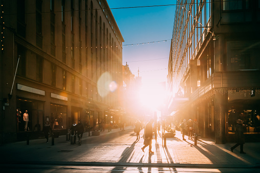 Helsinki, Finland. People Walking On Kluuvikatu Street In Winter Sunlight. Street Decorated For Christmas And New Year Holiday. Sunrise Morning Time