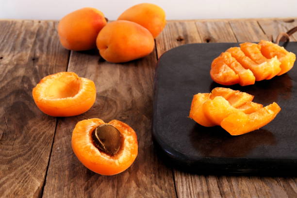 istock Cutting apricots on black stone cutting board 1021818024