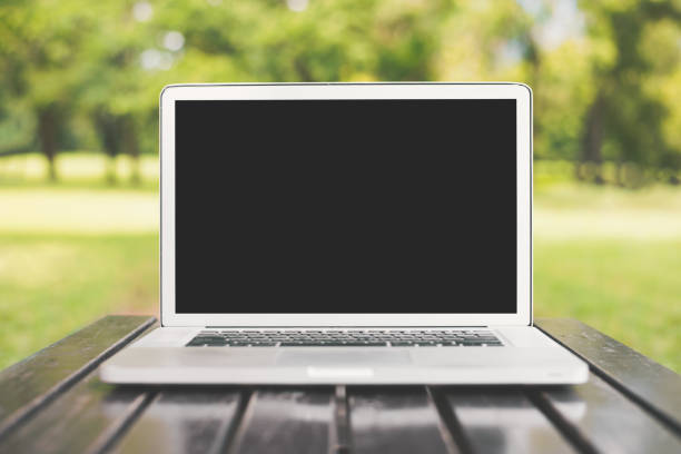 istock Laptop computer with blank black screen on green nature background. Natural and technology concept. Object and electronics theme. Front view angle 1021827016
