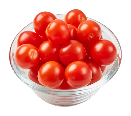 Fresh ripe tomatoes in glass bowl isolated on white background.