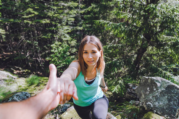 istock Girl climbs on rock, partner pulls out hand for assistance 1021841588