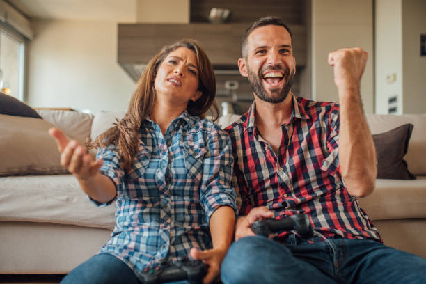istock Excited young man playing games with his displeased girlfriend 1021845366